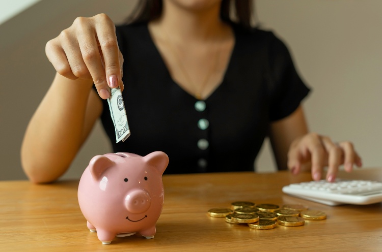 an-asian-female-student-is-putting-a-banknote-in-a-2023-11-27-05-20-58-utc-1