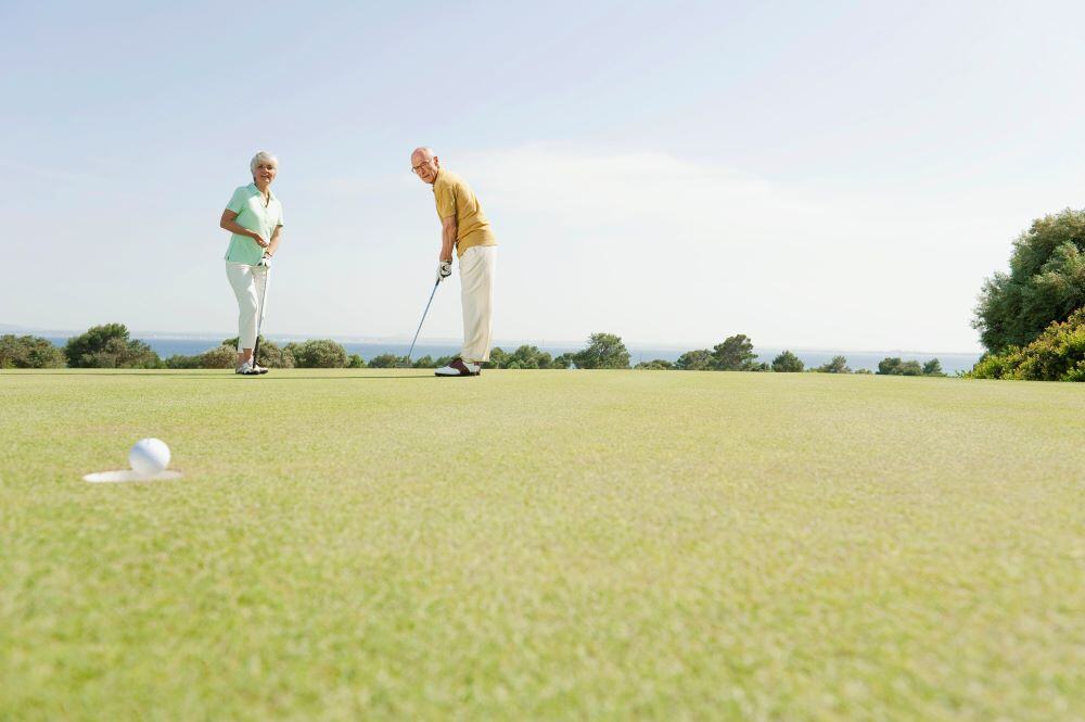 Older couple playing golf